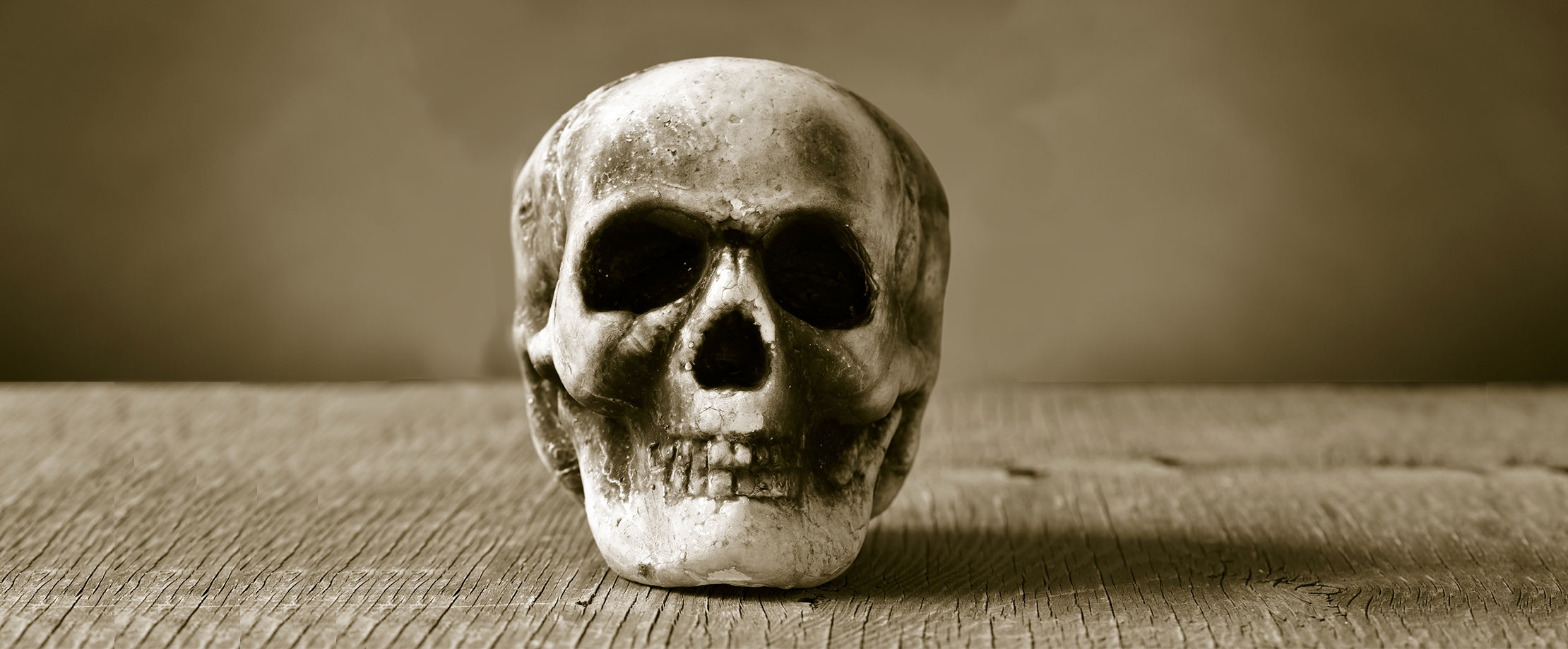 Ein gebastelter Totenschädel liegt auf einem braunen Tisch.